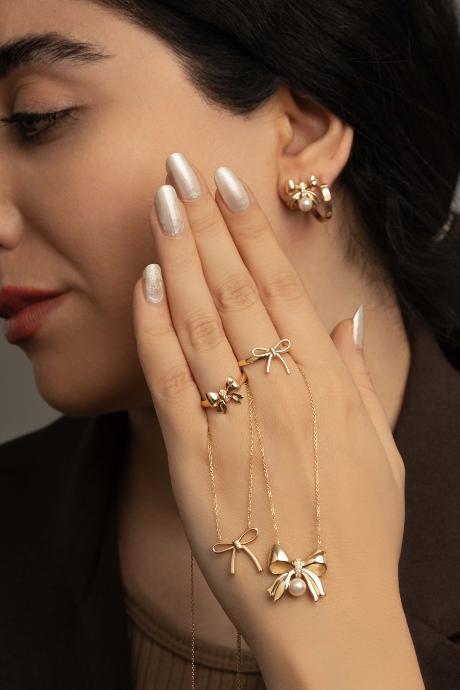 Woman wearing gold jewelry with pearl accents